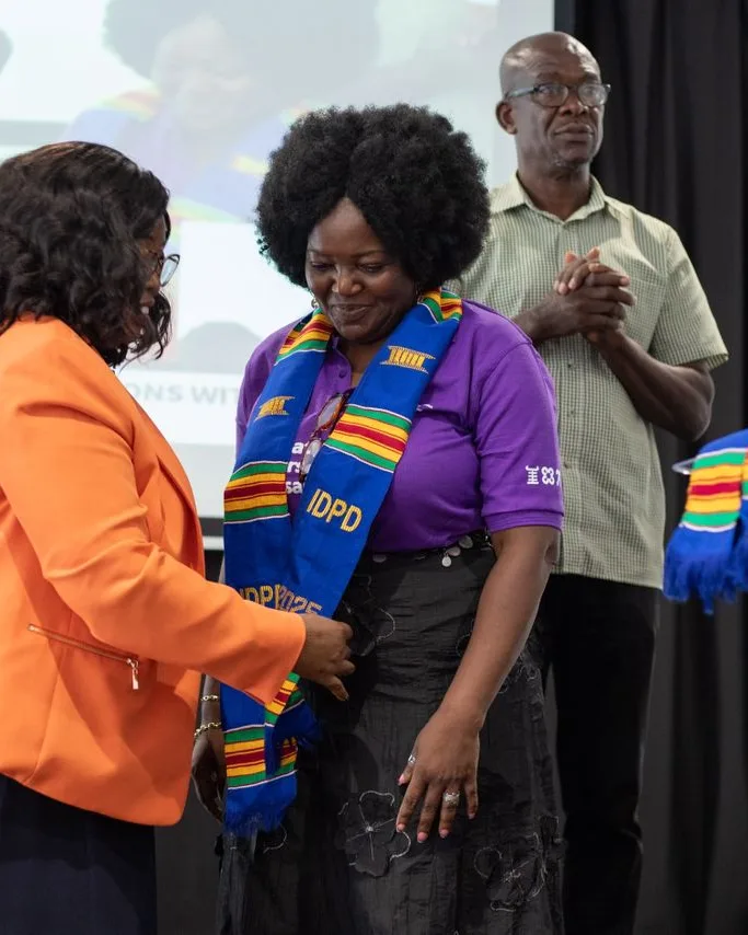 Eyram Bashan receiving a commemorative stole at an International Day of Persons with Disabilities ceremony.